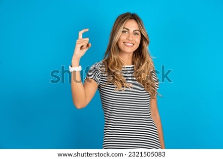 Young beautiful woman wearing striped t-shirt pointing up with fingers number nine in Chinese sign language Jiu
