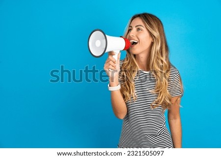 Young beautiful woman wearing striped t-shirt Through Megaphone with Available Copy Space
