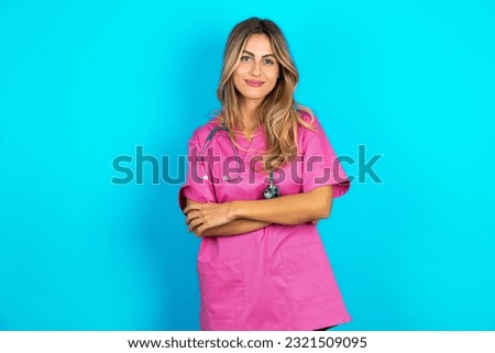 Self confident serious calm young beautiful doctor woman stands with arms folded. Shows professional vibe stands in assertive pose. Royalty-Free Stock Photo #2321509095