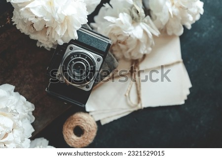 Summer background, flat lay layout, peonies and retro camera.