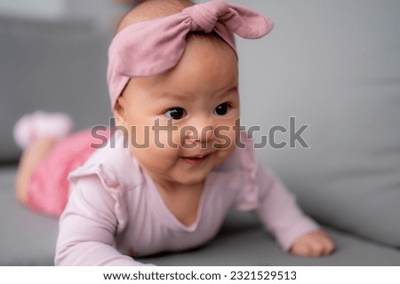 A baby girl doing tummy time, an infant small girl. Newborn premature baby. Royalty-Free Stock Photo #2321529513