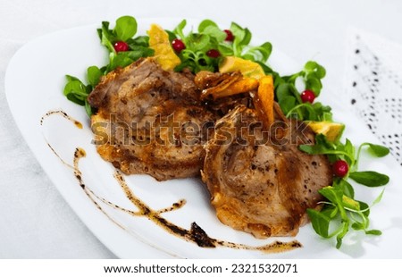 Tasty cooked fried pork chops with avocado, greens and berries at plate