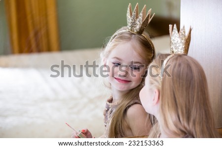 The little princess looks in the mirror Royalty-Free Stock Photo #232153363