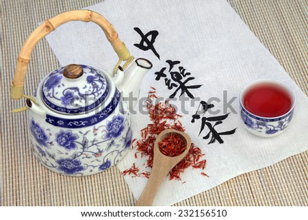 Safflower herb tea also used in chinese herbal medicine, with teapot, cup and calligraphy script on rice paper. Translation reads as chinese herbal tea.