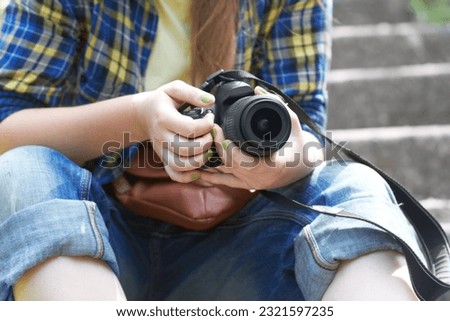 Woman, photographer hands and camera for travel picture sitting on garden steps. Journey, photo and photography of a female person in a urban park traveling and outdoor on holiday with hobby