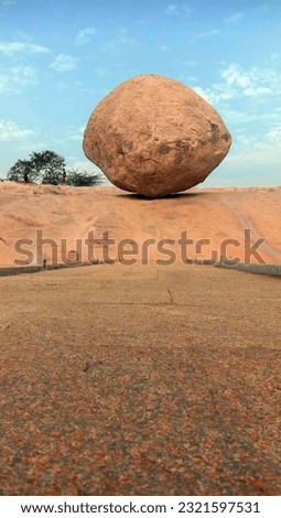 A massive 20 feet high and 5 meter wide rock boulder known as Krishna’s Butterball in Mahabalipuram with 250 ton, stands on a slippery slope of a hill on less than 4-feet base. Royalty-Free Stock Photo #2321597531
