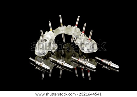 navigational surgical template and drills for dental implantation operations isolated closeup on a black background Royalty-Free Stock Photo #2321644541