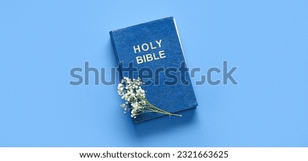 Holy Bible and flowers on blue background