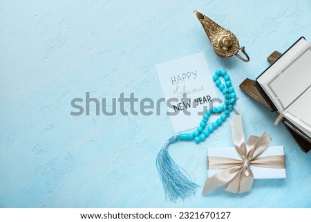 Card with text HAPPY ISLAMIC NEW YEAR, tasbih, Aladdin lamp and Koran on color background Royalty-Free Stock Photo #2321670127