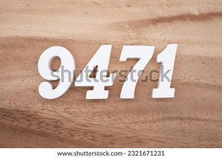White number 9471 on a brown and light brown wooden background.