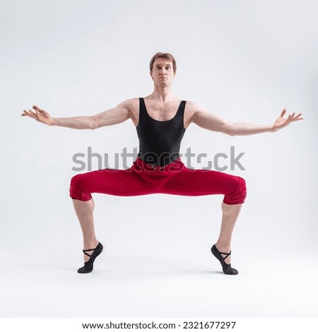 Concentrated Contemporary Ballet Dancer Flexible Athletic Man Posing in Red Tights in Ballanced Dance Pose With Hands Circled on White. Square Shot