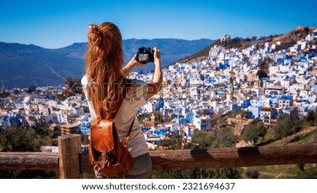 Woman tourist taking picture of blue city- Chefchaouen in Morocco