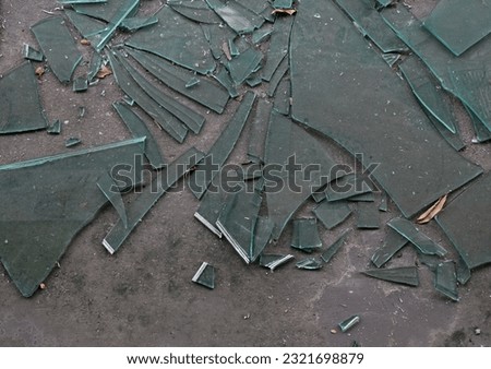 Cracked broken destroyed glass abstract texture on the cement floor background at Thailand.    