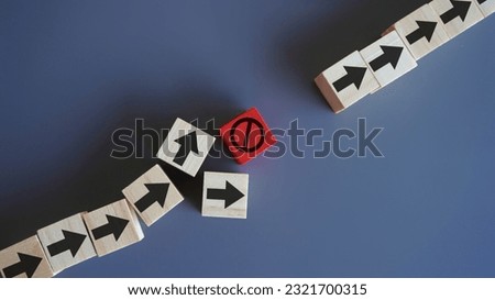 Wooden blocks with arrow and stop icon. Delays and disruptions, stop the process, critical error concept Royalty-Free Stock Photo #2321700315