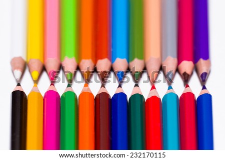 set of colored pencils lie on a white table
