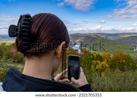 Young girl taking a picture of a beautiful landscape