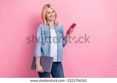 Photo of funny pensioner blonde hair wearing denim jacket jeans hold smartphone netbook content maker isolated on pink color background