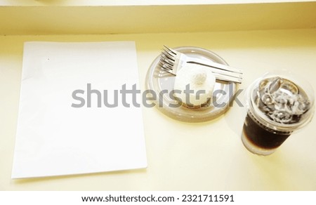 Top of blank book or magazine with cake and blurred glass of coffee on wooden table in flat lay concept.