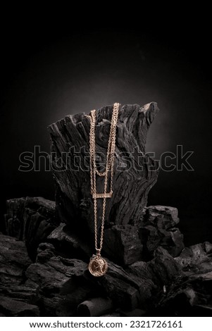 gold necklace with wood charcoal background Royalty-Free Stock Photo #2321726161