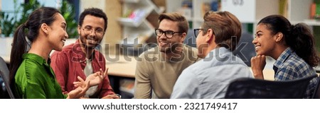 Creating success. Group of young happy multi racial business people communicating and sharing ideas while working together in the modern office Royalty-Free Stock Photo #2321749417