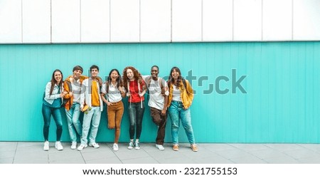 Diverse college students standing together on a blue wall - Photo portrait of multiracial teenagers in front of university building - Life style concept with guys and girls going to highschool  Royalty-Free Stock Photo #2321755153