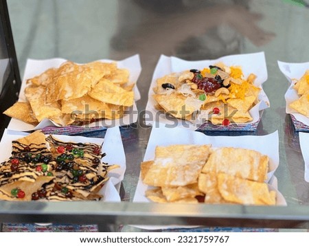 a photography of a table with a variety of nachos and chips, several trays of nachos and chips on a table