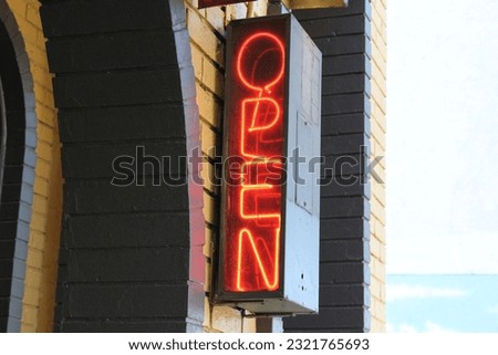 An old neon "Open" sign on the building wall