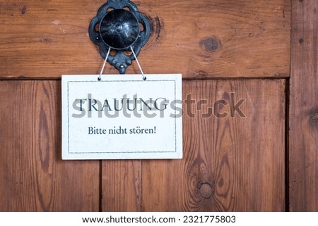 A closeup of a small sign on a door with the text: Wedding, do not disturb.