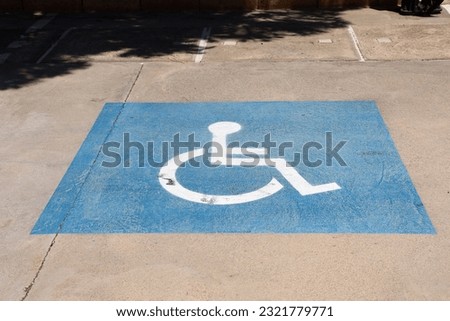 A preserved parking space for handicapped people in a parking lot during the daytime