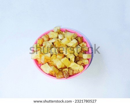 French fries in a pink bowl over a white background. Home made snack