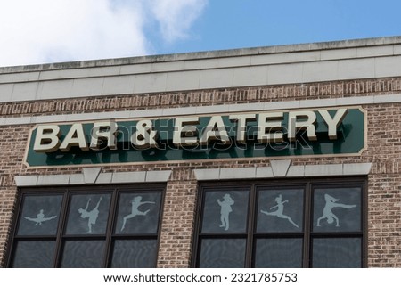A bar and eatery sign on the building
