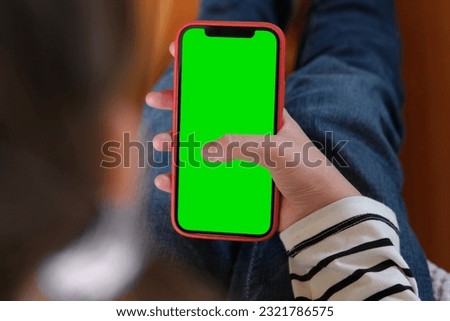 Teenage girl of 12 years with backpack holds a mobile phone green screen, chromakey. Advertising. Children's app, education, learning a foreign language. School Child showing smartphone greenscreen.