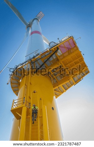 Offshore wind turbine technician climbing  Royalty-Free Stock Photo #2321787487