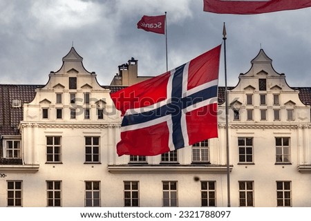 The Norway flag and the facade of a historical building in Bergen, Norway Royalty-Free Stock Photo #2321788097