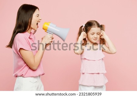 Happy woman wearing casual clothes with child kid girl 6-7 years old. Mother daughter holding scream in megaphone say Hurry up, cover ears isolated on plain pink background. Family parent day concept Royalty-Free Stock Photo #2321805939