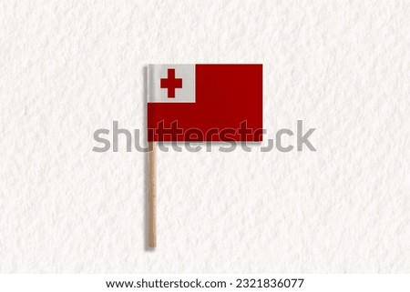 The Flag of Tonga with Wooden Pole on White Paper.