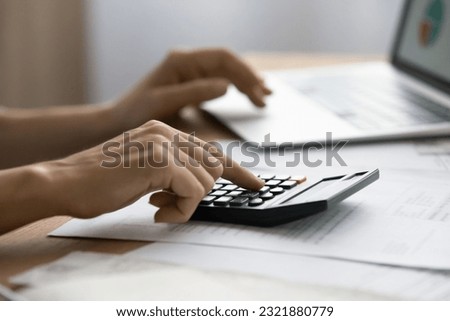 Close up successful business lady calculating online project expenditures, managing income or outcome using computer applications, reviewing sales or developing marketing strategy at home office. Royalty-Free Stock Photo #2321880779