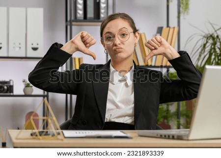 Dislike. Upset Caucasian business woman girl working on laptop computer at office thumbs down sign gesture, expressing discontent, disapproval dissatisfied bad work. Displeased serious freelancer girl