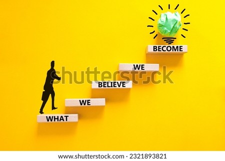 We become or believe symbol. Concept word What we believe We become on wooden block. Beautiful yellow table yellow background. Businessman icon. Business we become or believe concept. Copy space. Royalty-Free Stock Photo #2321893821