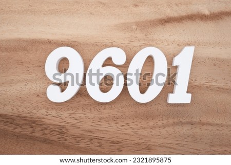 White number 9601 on a brown and light brown wooden background.