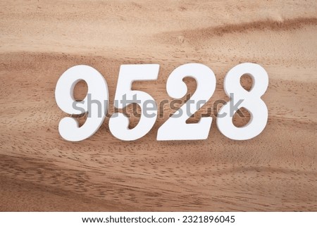 White number 9528 on a brown and light brown wooden background.