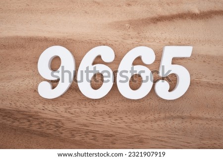 White number 9665 on a brown and light brown wooden background.
