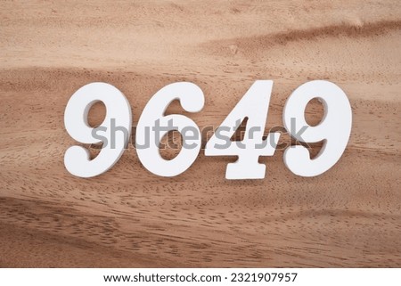 White number 9649 on a brown and light brown wooden background.