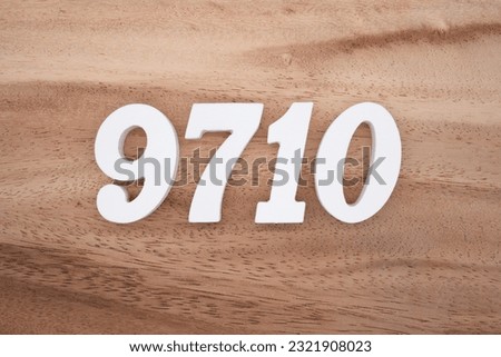 White number 9710 on a brown and light brown wooden background.
