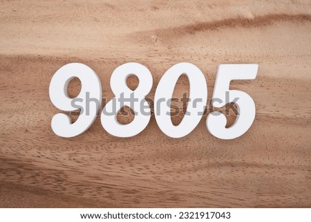 White number 9805 on a brown and light brown wooden background.