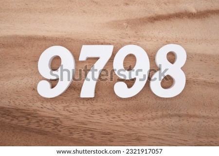 White number 9798 on a brown and light brown wooden background.