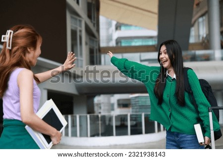 Two female students waved greeting and hug together ,  It's good to see you again. back to school of education concept  "SSTKUNIVERSITY" Royalty-Free Stock Photo #2321938143