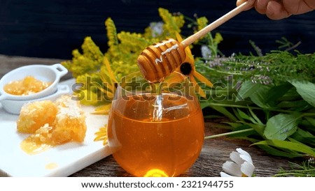 A honey dipper is pouring liquid into a glass.Good honey pictures.