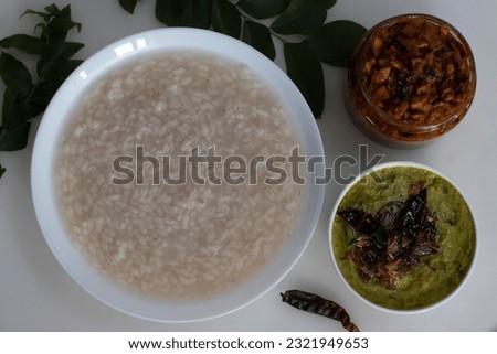 Kanji and Kadumanga. Rice gruel prepared with Kerala Matta rice. Served with raw banana curry and Kerala style cut mango pickle. Shot on a white background.