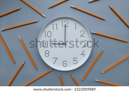 9 o'clock, morning. Study time. Back to school. Watch with white clock face on blue table background with pencils. Concept of study, workday, deadline, schedule. New day. Beginning of week. Royalty-Free Stock Photo #2322009889